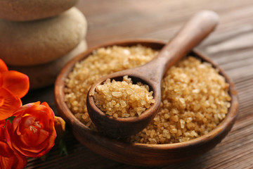 Beautiful exotic flowers, pebbles and sea salt in a bowl on wooden background