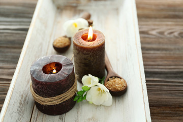 Fototapeta na wymiar Spa set with sea salt, flowers and candles on wooden background