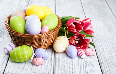 Obraz na płótnie Canvas basket with easter eggs and tulips
