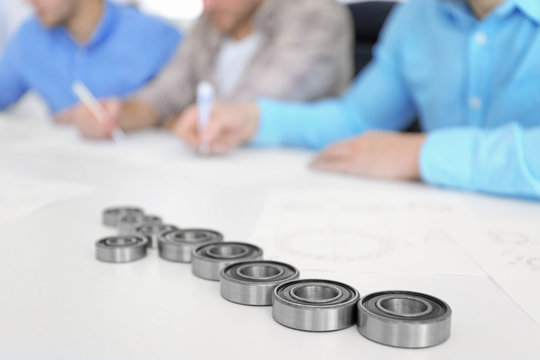 Engineers and bearings on table, closeup
