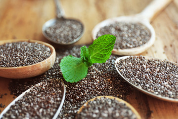 Spoons of chia seeds with mint leaves, closeup