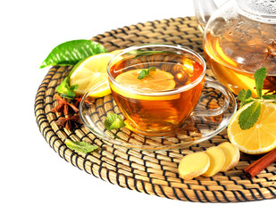 Cup of tea with ginger on a wicker mat isolated on white
