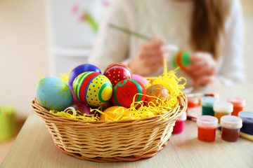 Fototapeta na wymiar Female hands painting Easter eggs at table indoors