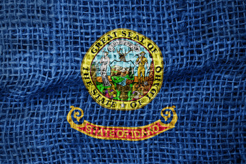 Idaho flag on sackcloth textured background