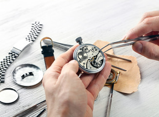 Watchmaker hands repairing mechanism of old watch closeup