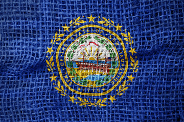 New Hampshire flag on sackcloth textured background