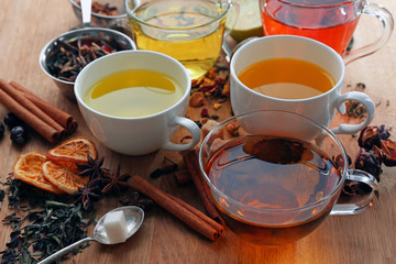 Cups with different kinds of tea and ingredients on table © Africa Studio