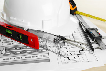 Construction drawings and other tools on wooden table closeup