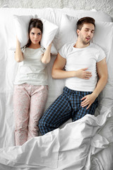 Young girl can't sleep because of her man's snoring.