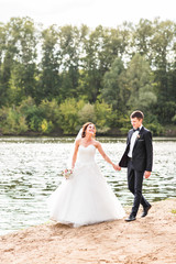 Wedding couple walking  near lake.