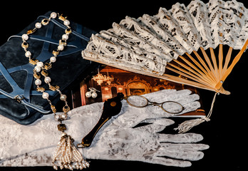 Theater accessories: fan, eyeglasses, gloves, jewelry.