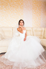 Beautiful bride in the interior sitting on couch
