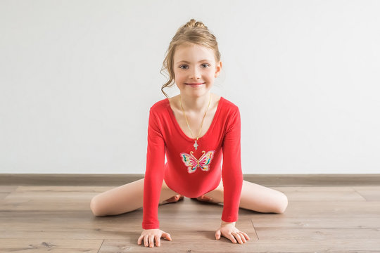 Flexible little girl in red leotard doing gymnastic