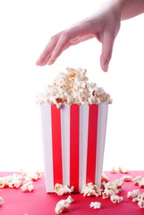Fototapeta premium popcorn and hand on isolated background