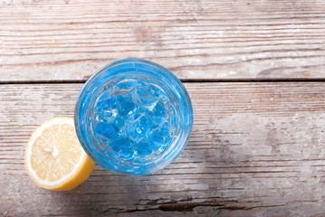 blue cocktail with lemon and ice