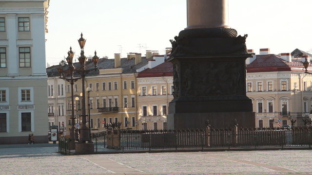 Early cold morining in Saint Petersburg, Russia. Low sun shines and reflects on facades of buildings. Rare passer-by's are crossing Palace square.