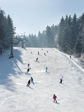 Skiers and snowboarders going down the slope