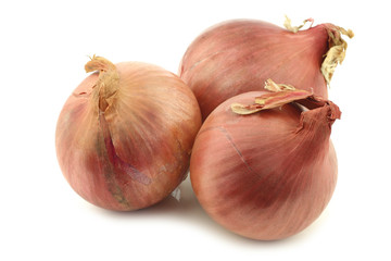 three pink onions on a white background