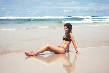 Fototapeta na wymiar Young pretty woman have sun bath on the cost of ocean