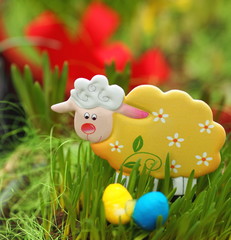 Fototapeta premium Easter lamb in a green grass - decorated flowerpot