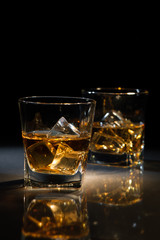 Glasses of whiskey with ice cubes