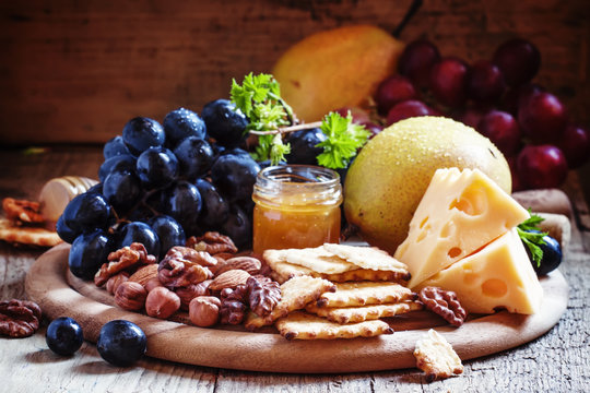 Snack plate: grapes, pears, hazelnuts, almonds, walnuts, cheese