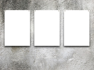 Close-up of three nailed blank frames on grey scratched wall background