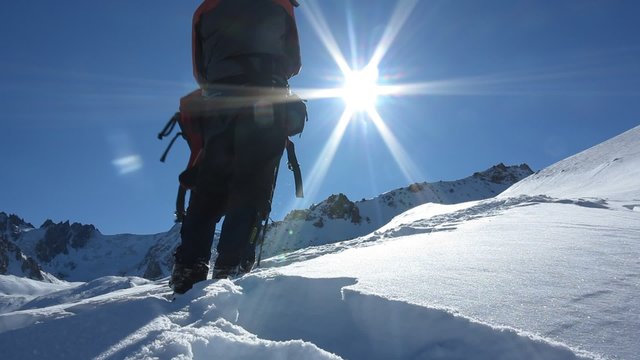 tourist with a backpack walking on snow-covered mountain path