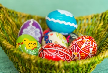 Closeup of beautiful colorful hand painted easter eggs in basket. Selective focus