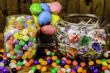 assorted candy and colored eggs in glass jars