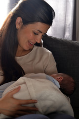 Madre latina compartiendo con su bebe en el hogar.