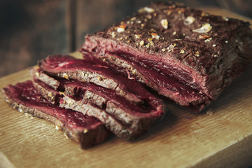Closeup focus grilled meat thin sliced on wooden board