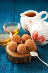 Homemade chocolate sweets and teaware with green tea on navy blu