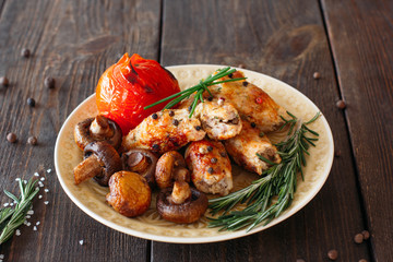 Shish kebab with baked tomato and mushrooms. Spicy shish kebab on wooden table. Homemade supper with fresh vegetables.