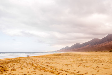 Fototapeta na wymiar Cofete beach at the cloudy and foggy weather on Fuerteventura island in Spain
