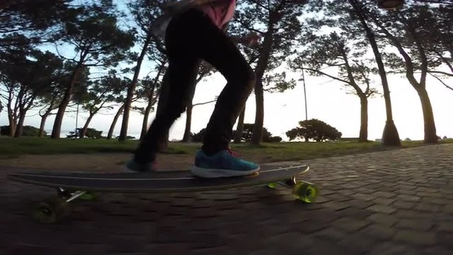 Riding longboard at sunset near at the sea side