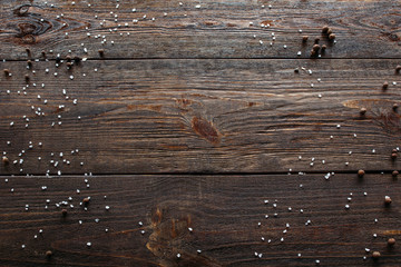 Void wooden background of cutting board with wooden texture and scattered spices on it. Top view on...