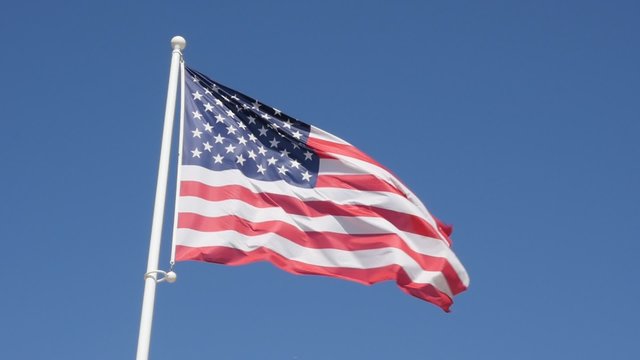 American flag fabric on the wind slow motion waving 1080p HD footage - United States of America flag against blue sky waving 1920X1080 slow-mo video 