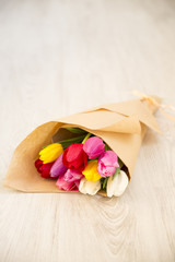 bouquet of fresh spring colourful tulips on wooden board