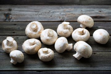 Fresh mushrooms champignons on wooden background