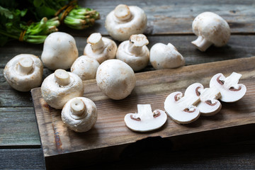 Obraz na płótnie Canvas Fresh mushrooms champignons on wooden background