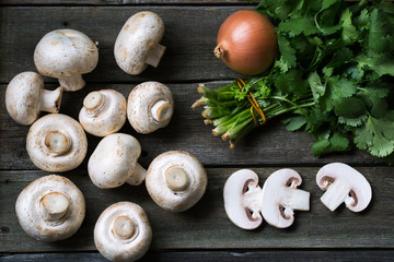 Fresh mushrooms champignons on wooden background