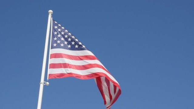American flag in front of blue sky slow waving on wind slow motion 1080p HD footage - United States of America flag against clear blue sky 1920X1080 FullHD slow-mo video 