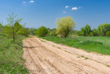 Fototapeta na wymiar Spring landscape with clay road in Ukraine