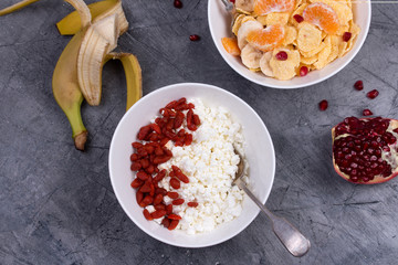 Healthy breakfast - corn flakes, goji, cottage cheese, milk and fruit. 