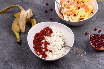 Healthy breakfast - corn flakes, goji, cottage cheese, milk and fruit. 