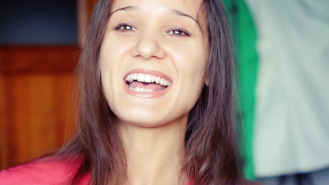 Happy attractive young woman having a video chat with her big Maine Coon cat. Looking directly at camera. 1920x1080