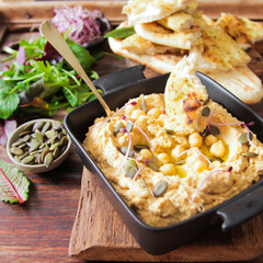 Classic hummus with parsley on the plate and pita bread