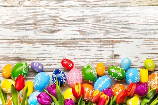 Easter eggs and tulips on wooden background