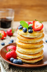pancakes with honey, strawberries and blueberries
